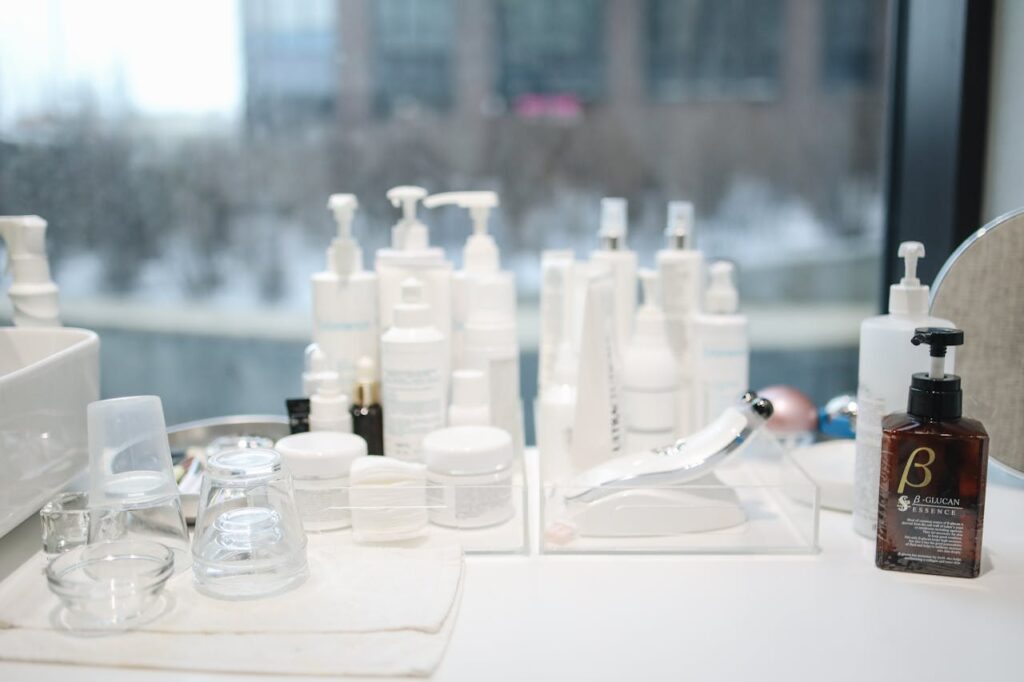 Assorted skincare products neatly arranged on a vanity near a large window